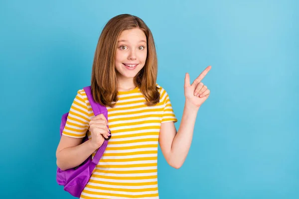 Foto di positivo amichevole scolaro indicano dito proposta di spazio vuoto isolato su sfondo di colore blu — Foto Stock