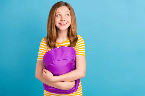 Sevimli pozitif okul çocuğu kolları çantasının fotoğrafı mavi arkaplanda izole edilmiş boş bir yere benziyor — Stok fotoğraf