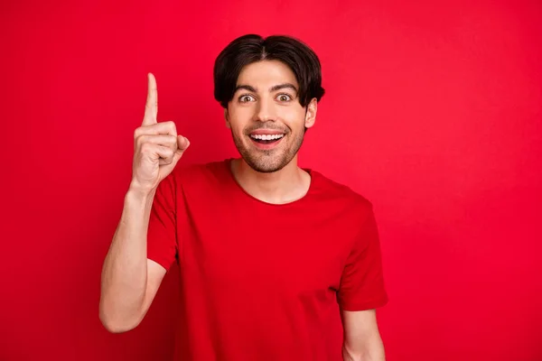 Foto van slimme creatieve man rijzen vinger hebben geweldig idee opgewonden gezicht dragen rood t-shirt geïsoleerde rode kleur achtergrond — Stockfoto