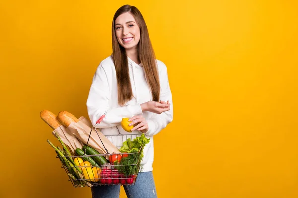 Foto de jovem alegre feliz mulher positiva segurar mão cesta limão comida isolada no fundo de cor amarela — Fotografia de Stock