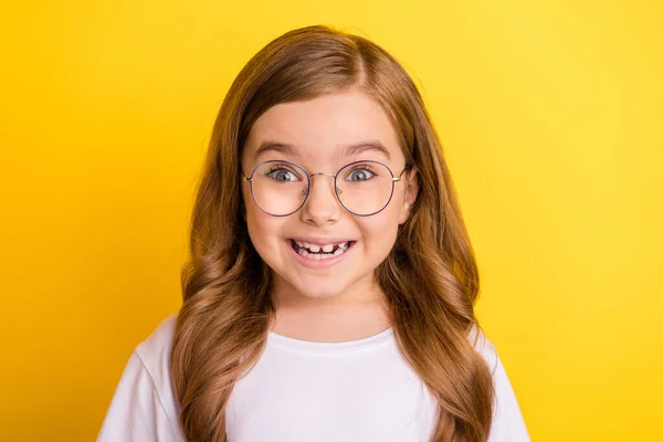 Photo of small funny blond girl wear spectacles white t-shirt isolated on yellow color background — Stock Photo, Image