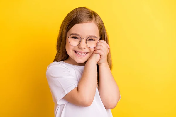 若いです小さい女の子幸せな正の笑顔手タッチ頬隔離上の黄色の色の背景 — ストック写真