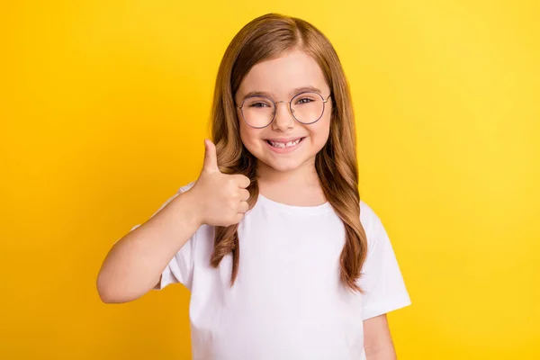 Foto von kleinen Mädchen glücklich positives Lächeln zeigen Daumen nach oben wie feine empfehlen Anzeige isoliert über gelben Farbhintergrund — Stockfoto