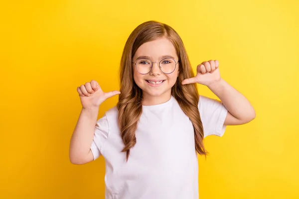 Foto von jungen kleinen Mädchen glücklich positives Lächeln Punkt Daumen selbst stolzer Sieger isoliert über gelben Farbhintergrund — Stockfoto