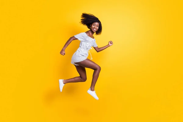 Tamanho do corpo de comprimento total vista de menina motivada alegre atraente pulando correndo rápido isolado sobre fundo de cor amarela brilhante — Fotografia de Stock