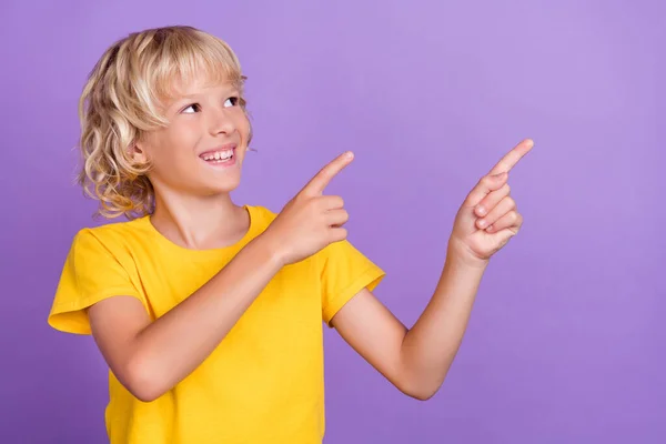 Foto de niño alegre alegre positivo punto dedo vacío espacio noticias curioso aislado sobre fondo de color violeta —  Fotos de Stock