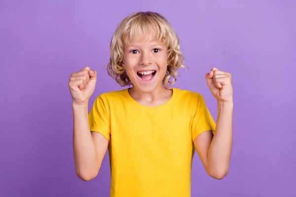 Photo positive joyeux jeune garçon heureux lever les poings gagnant sourire bonne humeur isolé sur fond de couleur pourpre — Photo
