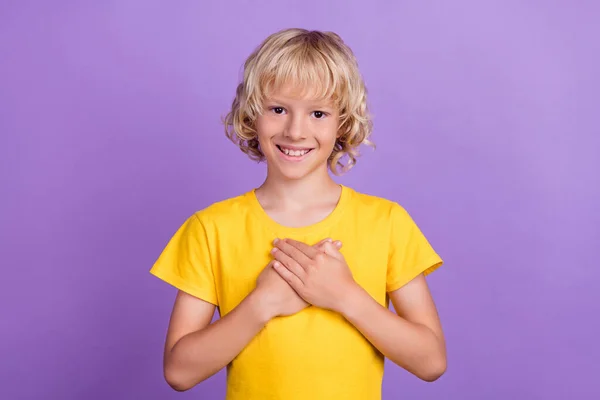 Zdjęcie pozytywne szczęśliwy uroczy chłopiec trzymać za ręce serce klatki piersiowej izolowane na fioletowy kolor tła — Zdjęcie stockowe
