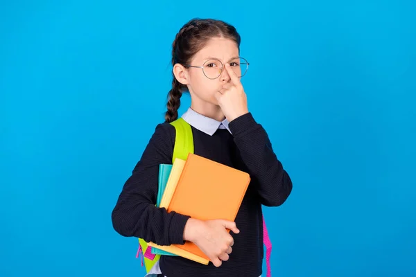 Photo of serious strict cool pewność uczennica dostosować okulary trzymać książki nosić plecak izolowany na tle niebieskiego koloru — Zdjęcie stockowe