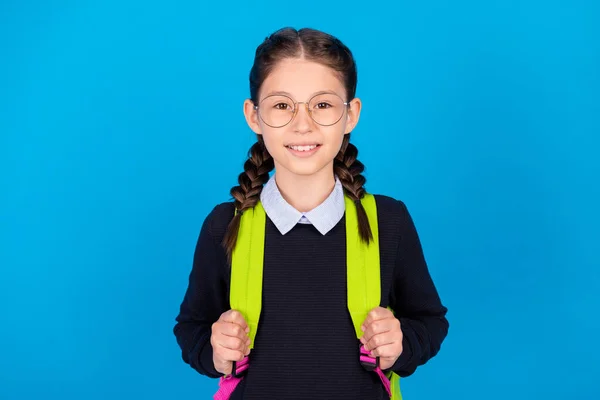 Foto di buon umore allegro intelligente intelligente studentessa indossare occhiali zaino occhiali isolati su sfondo di colore blu — Foto Stock