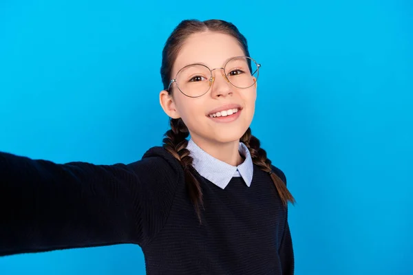 Foto de alegre hermosa inteligente inteligente colegiala tomar gafas de desgaste selfie aislar en fondo de color azul — Foto de Stock