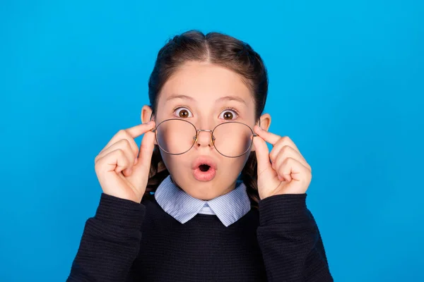 Foto von jungen Schulmädchen erstaunt schockiert überrascht Hände berühren Brille Vision isoliert über blauen Farbhintergrund — Stockfoto