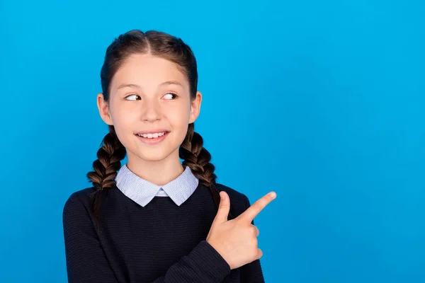 Foto van glimlachen mooie schoolmeisje reclame product bieden slijtage school uniform geïsoleerd op blauwe kleur achtergrond — Stockfoto