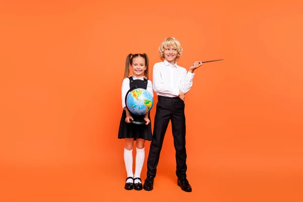 호기심 이 강한 두 아이의 사진 지구 포인터빈 공간을 잡고 균일하게 분리 된 오렌지 색 배경을 착용 — 스톡 사진