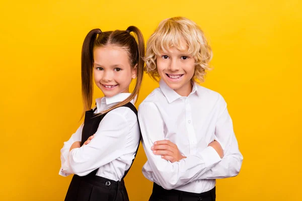 Photo of two self-assured schoolchildren crossed hands wear school uniform isolated yellow color background — Stock Photo, Image