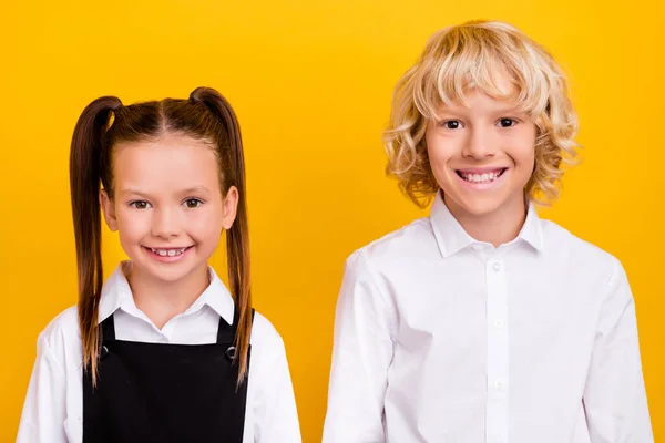 Photo de deux personnes satisfaites sourire regarder appareil photo ont bonne humeur isolé sur fond de couleur jaune — Photo