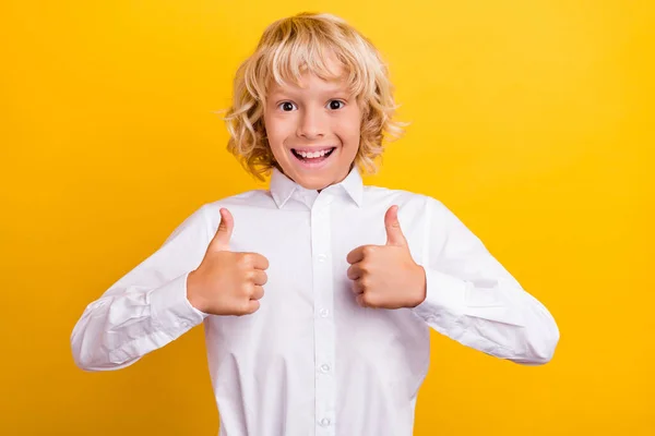 Foto av positiv skolpojke höja tummen upp godkänna val bära skolan uniform isolerad gul färg bakgrund — Stockfoto