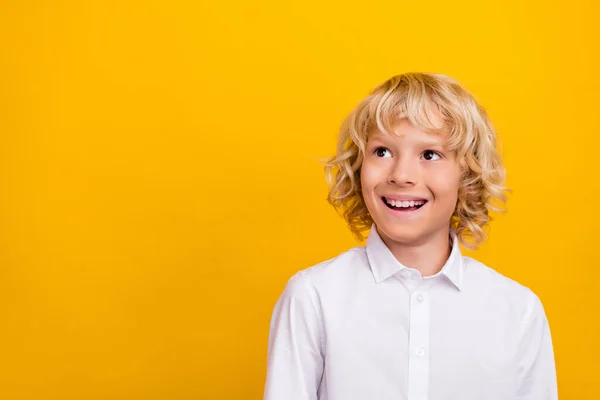 Photo de l'écolier blond inspiré rêveur intéressé look espace vide porter uniforme isolé fond de couleur jaune — Photo