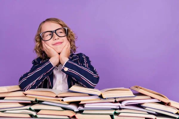 Portrét atraktivní zasněný veselý chlapec čtení hromádka knihy vytváření řešení izolované přes fialové fialové barvy pozadí — Stock fotografie