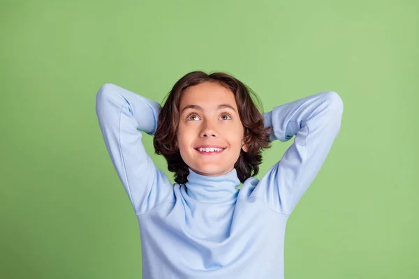 Retrato de atraente alegre sonhador menino de cabelos castanhos olhando para cima espaço de cópia isolado sobre fundo de cor verde brilhante — Fotografia de Stock