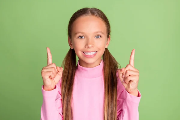 Retrato de menina alegre atraente demonstrando cópia espaço em branco anúncio isolado sobre fundo de cor verde brilhante — Fotografia de Stock