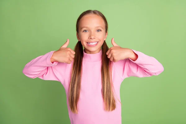 Портрет привабливої веселої дівчини, що показує два подвійних оголошення мініатюр ізольовані на яскраво-зеленому кольоровому фоні — стокове фото