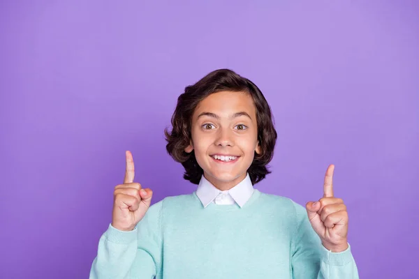 Foto von ziemlich süßen Schuljungen tragen Krippenpullover zeigt nach oben leeren Raum lächelnd isoliert lila Farbe Hintergrund — Stockfoto