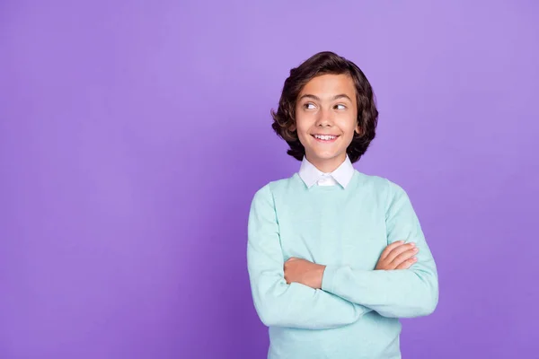Fotografie malého roztomilé brunet chlapec zkřížené paže vypadají prázdné místo nosit modrý svetr izolované na fialovém pozadí — Stock fotografie