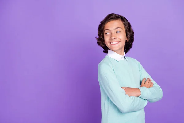 Profil zdjęcie małego cute brunet chłopiec skrzyżowane ramiona wyglądają puste miejsce nosić niebieski sweter izolowany na fioletowym tle — Zdjęcie stockowe