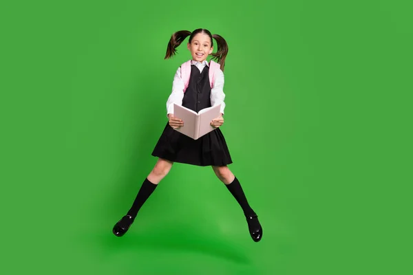 Full length body size άποψη του αρκετά χαρούμενο κορίτσι άλμα βιβλίο ανάγνωση απομονωμένη πάνω από φωτεινό πράσινο φόντο χρώμα — Φωτογραφία Αρχείου