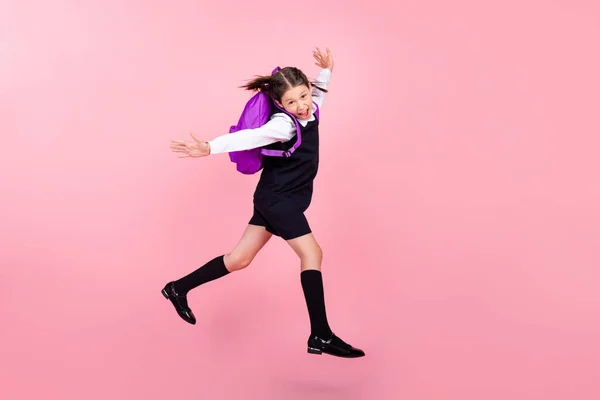 Longitud completa cuerpo tamaño foto colegiala saltar corriendo a la escuela con mochila aislado pastel rosa color fondo —  Fotos de Stock