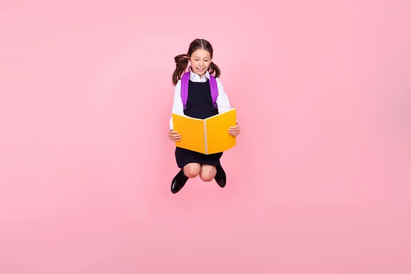 전체 몸길이의 사진 소녀 가방읽기 책가방을 들고 뛰어오르는 파스텔 핑크 색 배경 — 스톡 사진