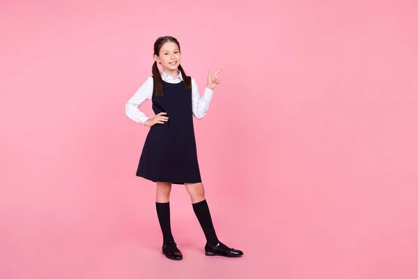 Full length body size photo schoolgirl showing empty space with hands isolated pastel pink color background — Stock Photo, Image