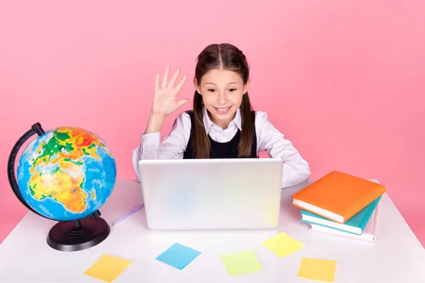 Foto retrato niña con colas sentada en el escritorio utilizando la educación remota portátil aislado pastel de color rosa fondo —  Fotos de Stock