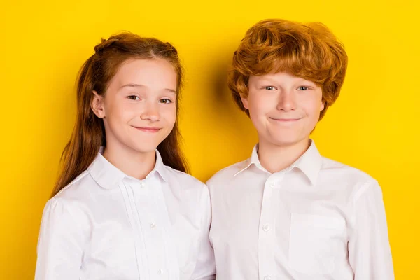 Портрет двух улыбающихся милых детей брат и сестра идут в школу первый день изолированы на желтом фоне цвета — стоковое фото