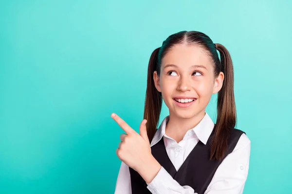 Foto retrato niña en uniforme mostrando el dedo vacío espacio soñador aislado pastel color turquesa fondo — Foto de Stock