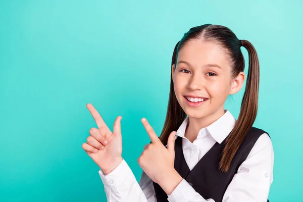 Φωτογραφία πορτρέτο κοριτσάκι με στολή δείχνοντας το δάχτυλο κενό χώρο χαμογελώντας απομονωμένο παστέλ τυρκουάζ φόντο χρώμα — Φωτογραφία Αρχείου