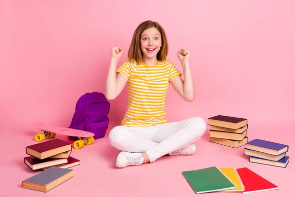 Foto de alegre chica encantadora sentarse piso celebrar victoria desgaste rayas amarillo camiseta aislado color rosa fondo —  Fotos de Stock