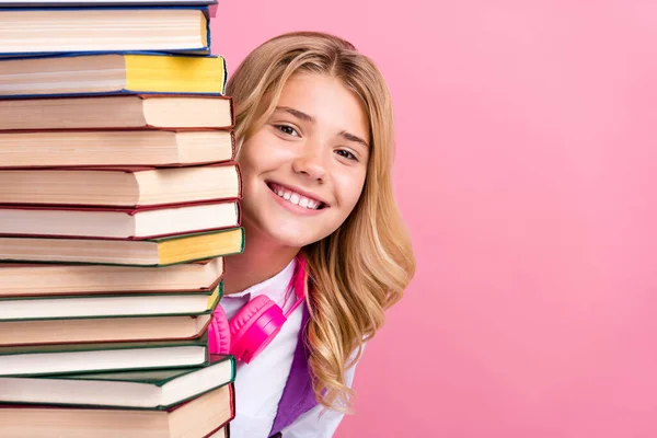 Retrato de chica alegre atractiva escondido detrás de la pila libro copia espacio aislado sobre fondo de color pastel rosa — Foto de Stock