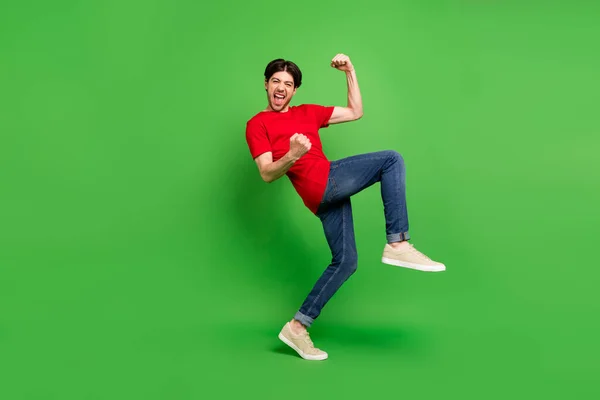 Foto von erstaunt Champion Kerl feiern Sieg schreien ja tragen rotes T-Shirt isoliert grüne Farbe Hintergrund — Stockfoto