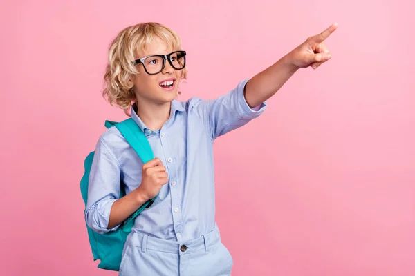 Foto de doce impressionado estudante desgaste azul camisa óculos mochila olhando apontando espaço vazio isolado cor rosa fundo — Fotografia de Stock