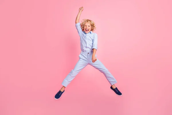 フルサイズ写真のファンキー面白いです屈託のない笑顔の学校の少年ジャンプ周りのピンクの色の背景に孤立 — ストック写真