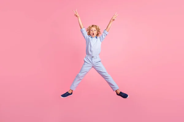 Фотографія повного розміру молодого шокованого здивованого стрибка школяра, що показує перемогу v-знака ізольовано на рожевому кольоровому фоні — стокове фото