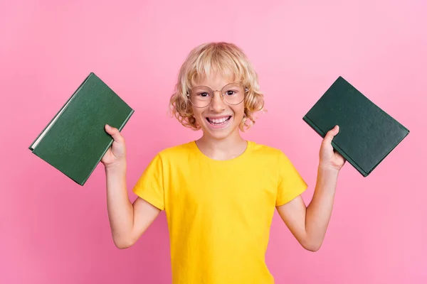 Foto di giovane allegro piccolo ragazzo allievo felice sorriso positivo tenere libro studio isolato su sfondo di colore rosa — Foto Stock