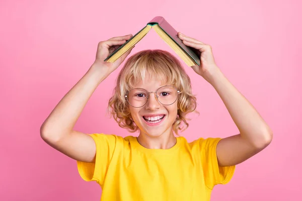 Foto de niño de la escuela feliz sonrisa positiva celebrar libro casa techo engañando aprender aislado sobre fondo de color rosa — Foto de Stock