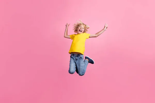 Foto de longitud completa de joven alegre niño feliz sonrisa positiva salto mostrar paz v-signo aislado sobre fondo de color rosa —  Fotos de Stock