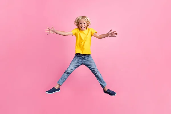 Pleine longueur photo de jeune garçon heureux sourire positif sauter mains ouvertes étreinte amical isolé sur fond de couleur rose — Photo