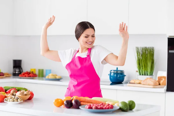 Φωτογραφία από αστεία καστανά μαλλιά Millennial κυρία χορό σπίτι φορούν λευκό t-shirt ποδιά στην κουζίνα — Φωτογραφία Αρχείου