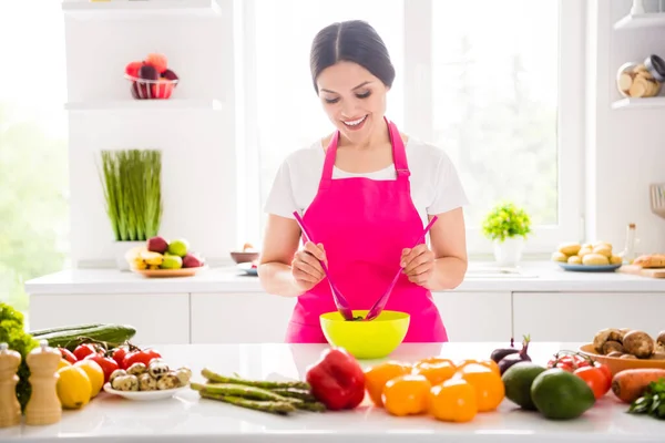 Foto di bella affascinante donna matura vestita di rosa grembiule sorridente cucina mescolando insalata al chiuso casa stanza di casa — Foto Stock