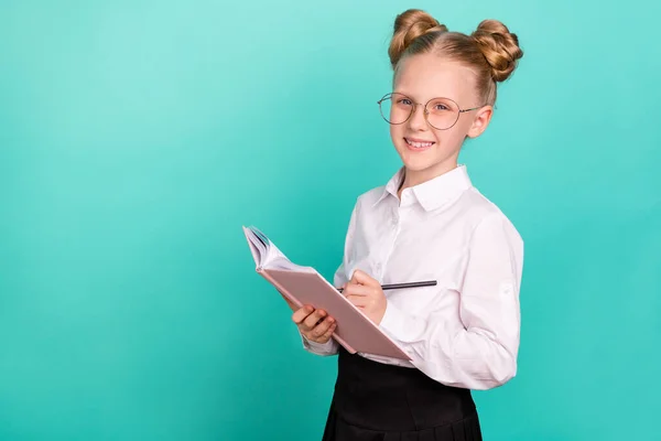 Foto van schattig klein meisje schrijven copybook dragen witte shirt bril geïsoleerd op teal achtergrond — Stockfoto